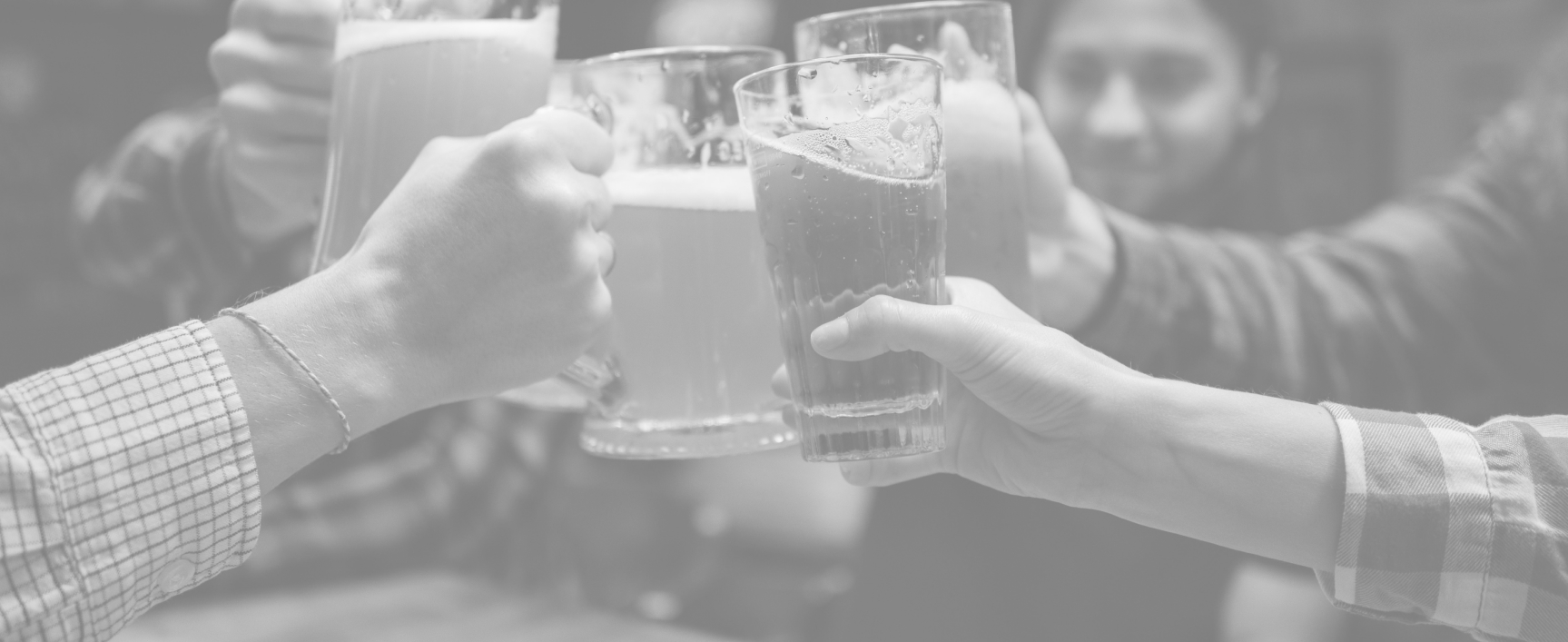 several people cheering with a glass of craft beer in black and white