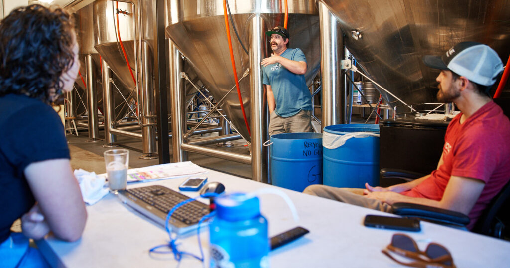 Two people at a brewery table, participating in a tasting event featuring Master Brewer Chris Danforth.